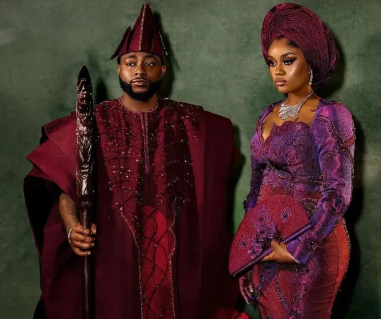 Davido and Chioma in their high profile wedding aso oke, davido is wearing a burgundy colored agbada while chioma is wearing a duotone aso oke dress and gele with cutout detailing.