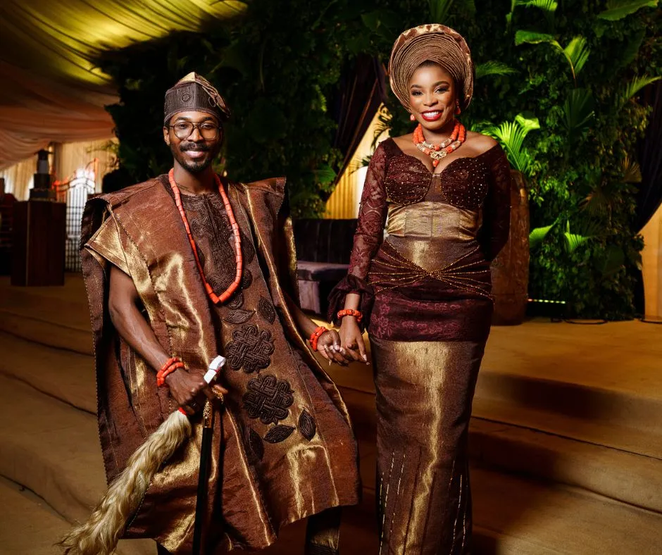 Made and Inedo kuti in matching wedding aso oke - made is wearing a metallic brown gold aso oke agbada while inedo is in a dutone metallic gold and brown dress